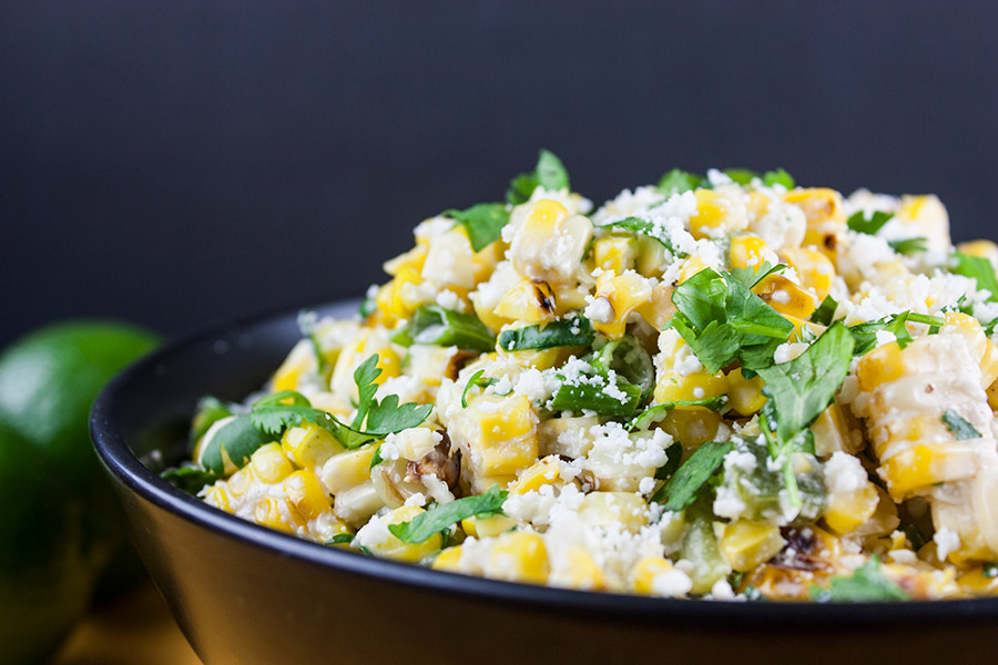 side view closeup of the Grilled Mexican Street Corn Salad in a black bowl