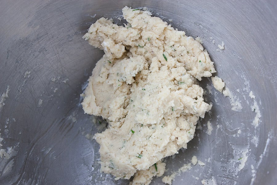 Parmesan rosemary shortbread dough mixed in a silver bowl.