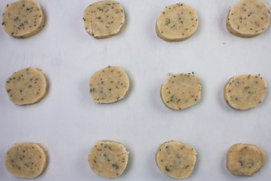 Parmesan Rosemary Shortbread rounds on a parchment lined baking sheet.