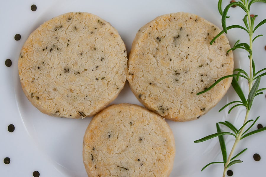 Savory Parmesan Rosemary Shortbread on a white plate garnished with fresh rosemary sprig.