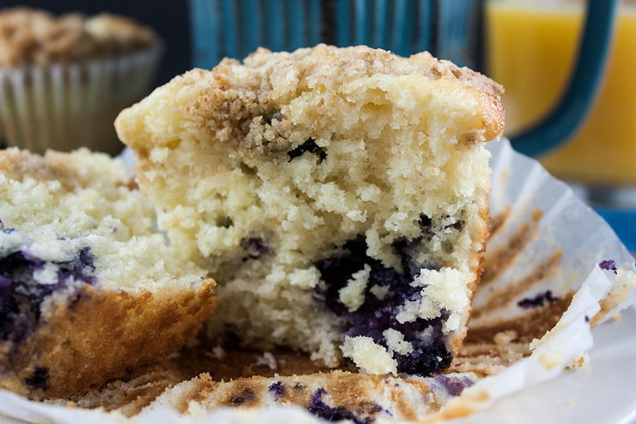 a Lemon Streusel Blueberry Muffin cut in half on a white plate