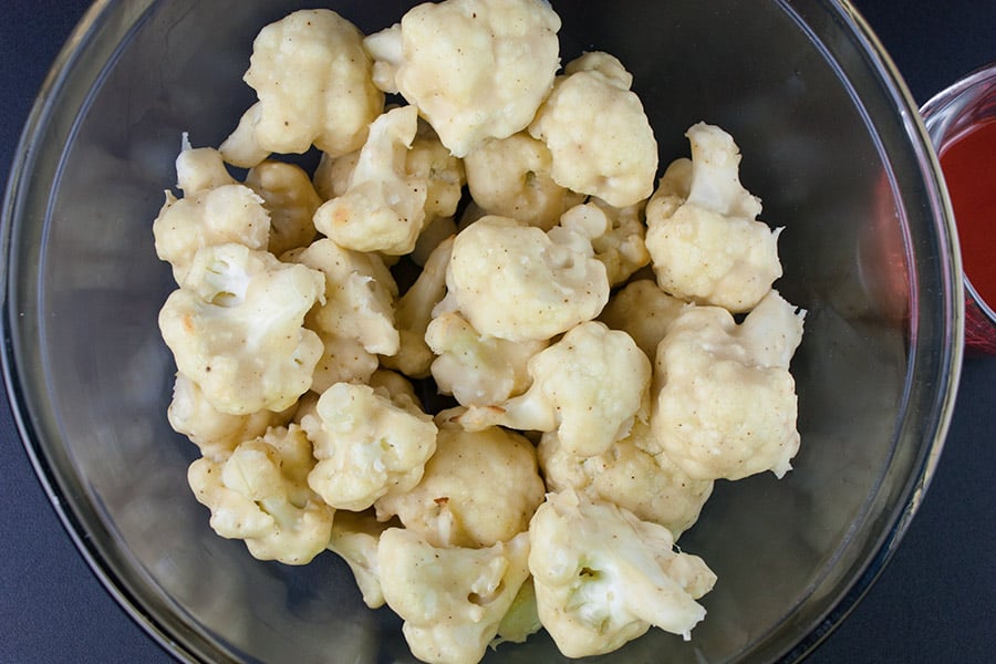 Baked Buffalo Cauliflower Bites in a glass mixing bowl