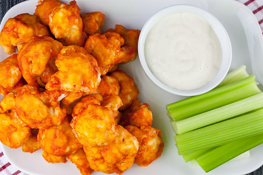 Baked cauliflower bites on a white platter with celery