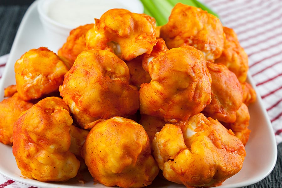 Baked Buffalo Cauliflower Bites - on a white platter with celery and ranch dressing