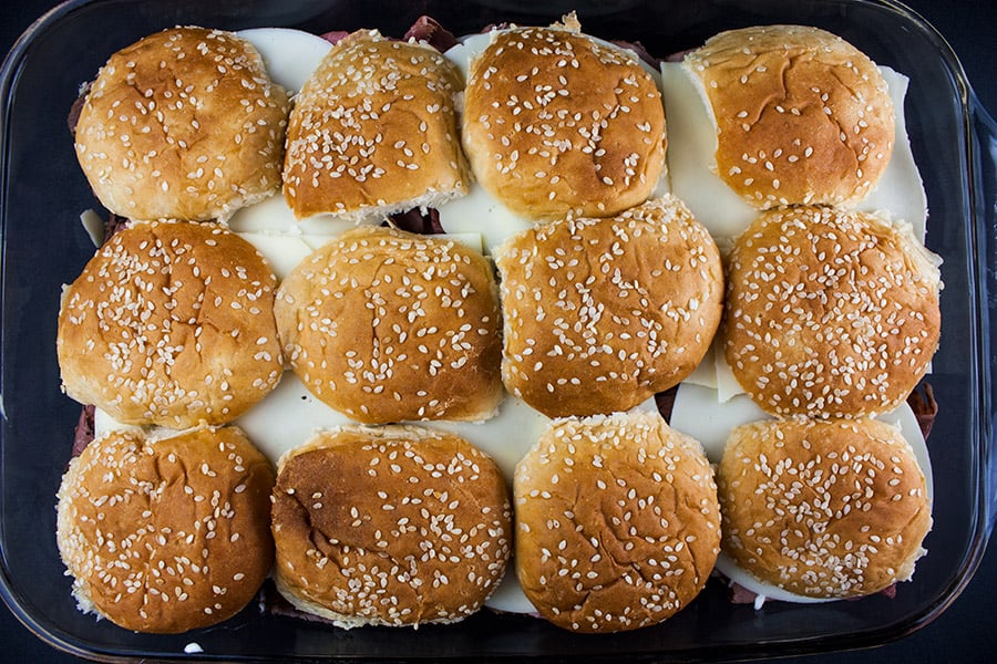 Top buns place on the roast beef sliders in the baking dish.