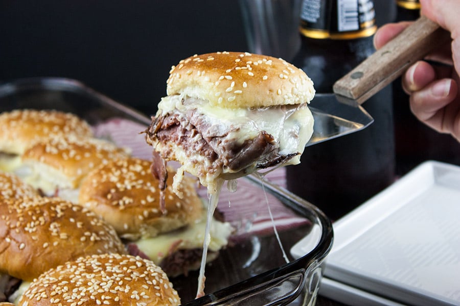 Roast beef slider lifted out of the pan on a spatula.