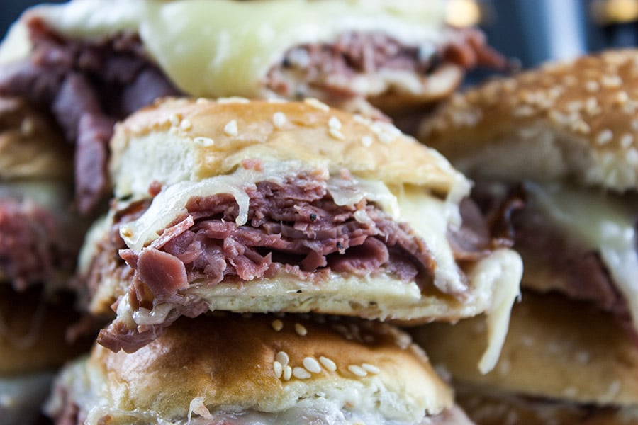 Roast Beef Sliders with Horseradish Sauce stacked on a platter.