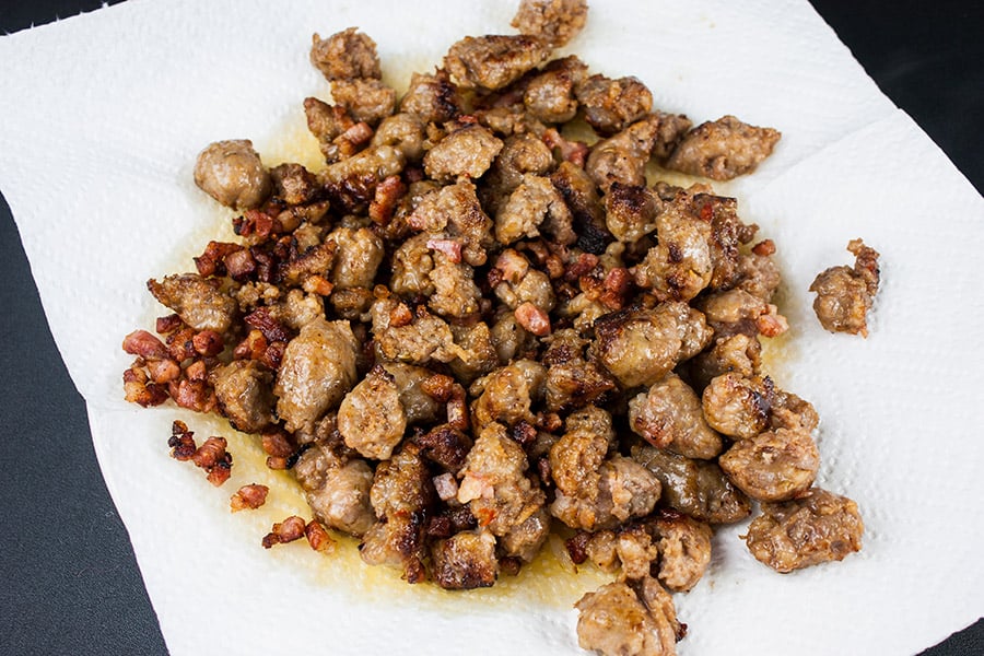 Italian Sausage Rigatoni with Spicy Tomato Cream Sauce - browned Italian sausage and pancetta draining on a paper towel