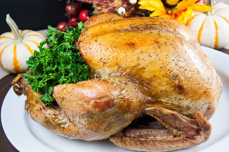 Simple Succulent Dry Brined Roast Turkey on a white platter.