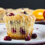 Cranberry orange muffins on a white plate with red dots.