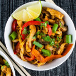 Spicy Thai Chicken Noodle Bowl garnished with a lime wedge.