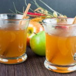 Slow Cooker Apple Cider in glass mugs with cinnamon sticks.