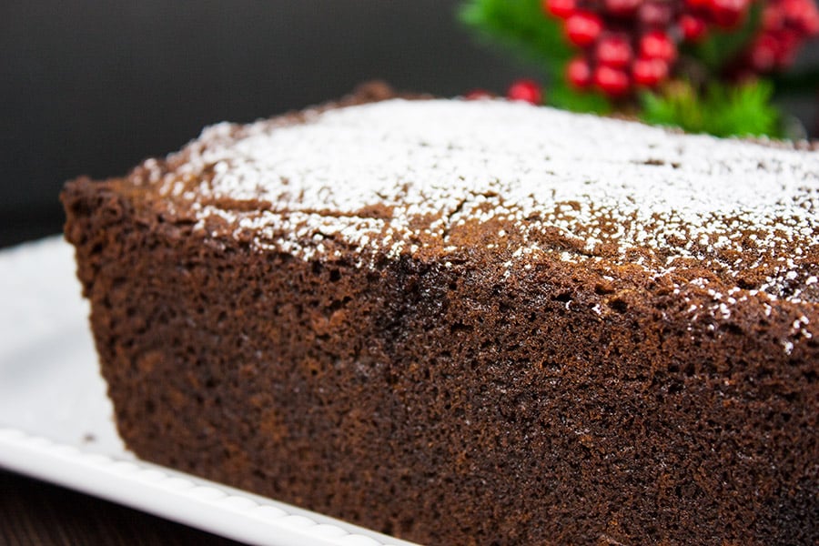 Spicy Gingerbread Loaf on a white platter garnished with powdered sugar