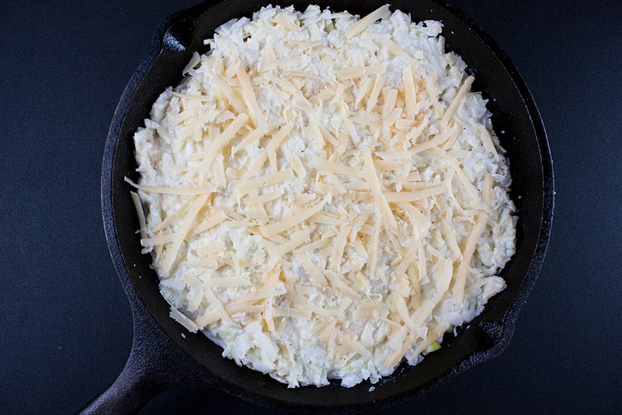 Baked Vidalia Onion Dip in a cast iron skillet topped with shredded cheese
