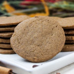 Gingersnap cookies stacked on a white plate.