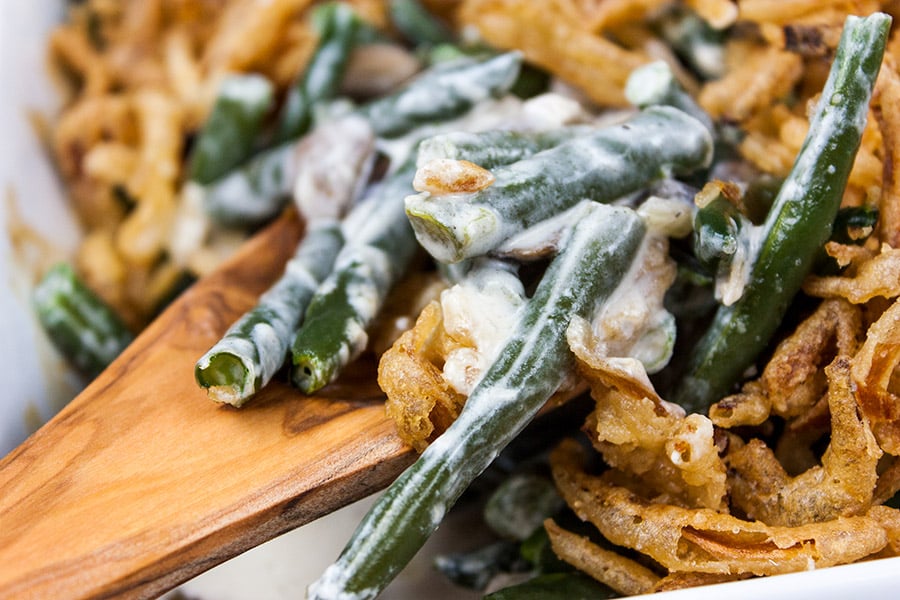 A scoop of green bean casserole on a serving spoon.