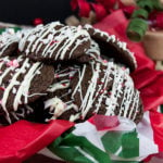Chocolate Peppermint Cookies stacked in tin with red, white and green tissue paper.