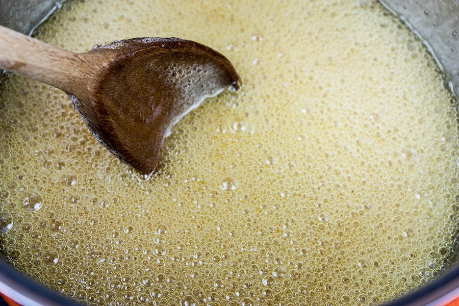 Sugar, water, and syrup boiling in a saucepan.