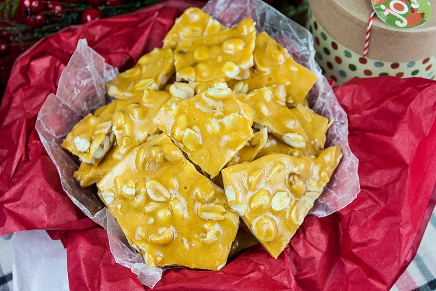 Old-Fashioned Peanut Brittle in a tin lined with red tissue paper.