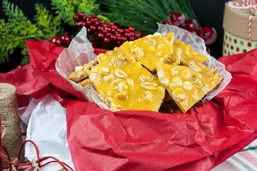 Old-Fashioned Peanut Brittle in a tin lined with red tissue paper.