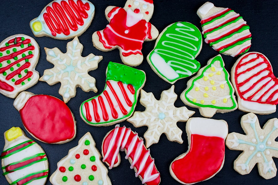 Decorated cut out sugar cookies on a dark background.