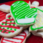 Decorated cut-out sugar cookies on red plate.