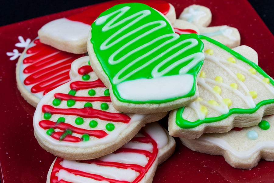 Decorated cut-out sugar cookies on red plate.