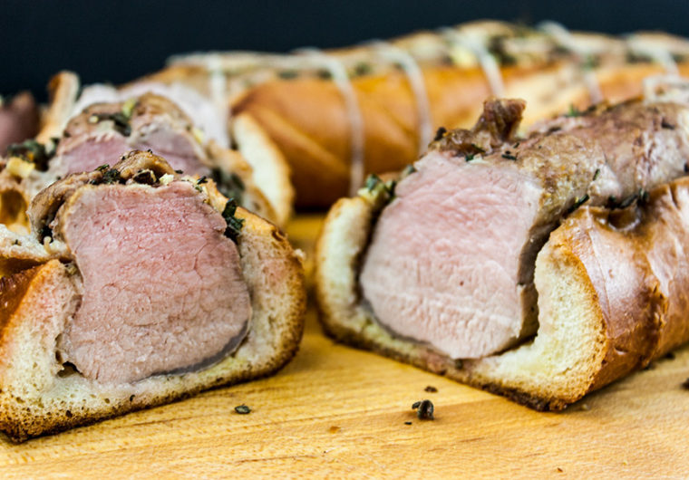 Tuscan pork tenderloin sliced on wooden cutting board