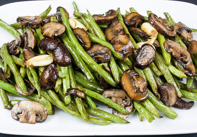 roasted green beans and mushrooms on a white serving platter