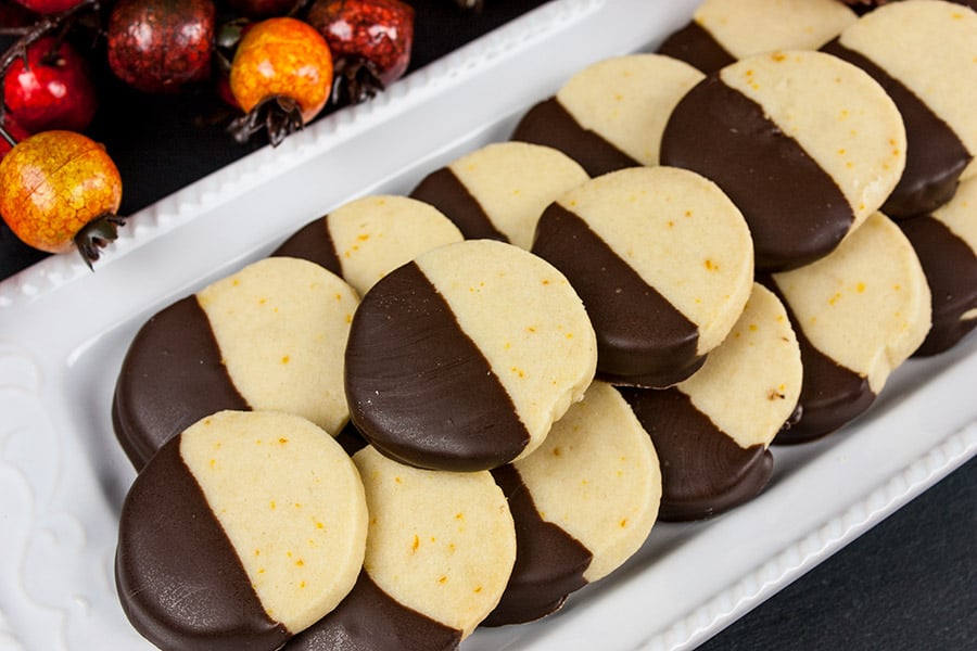 Chocolate orange cookies stacked on white platter