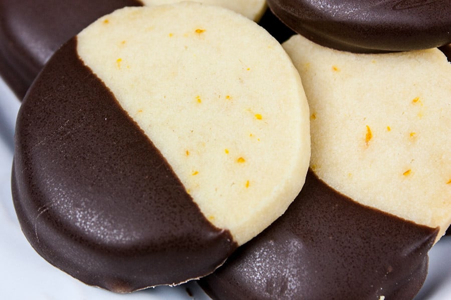Chocolate orange shortbread cookies stacked on a light plate.