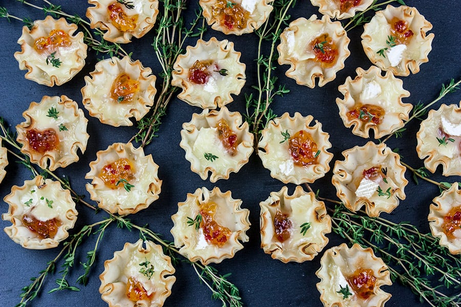 Pepper Jelly Brie Bites on a black slate garnished with fresh thyme