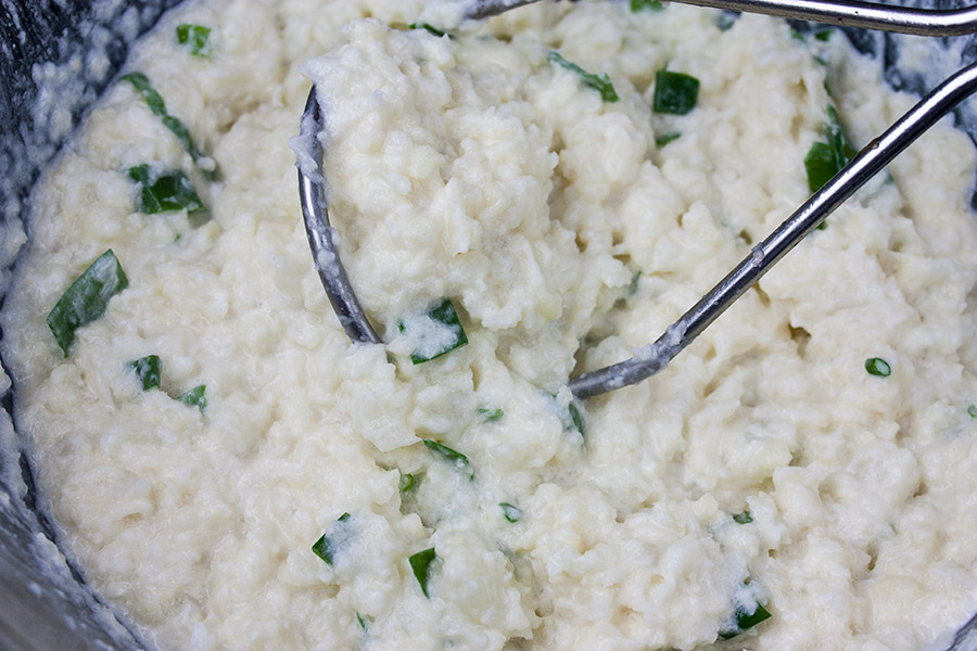 Loaded Cauliflower Mash Casserole - cauliflower mashed in a bowl with seasonings