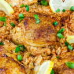 One Pan Spanish Chicken and Rice with a green onion garnish.