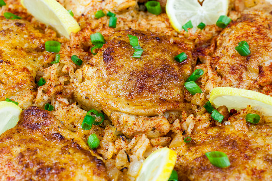 One Pan Spanish Chicken and Rice with a green onion garnish.