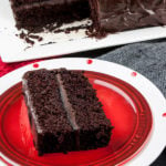 A slice of dark chocolate espresso cake on a red plate.