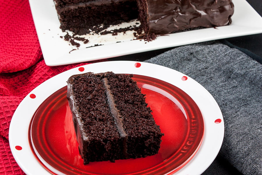 A slice of dark chocolate espresso cake on a red plate.