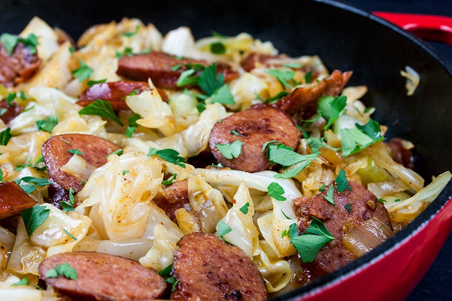 Fried cabbage and sausage in a skillet.