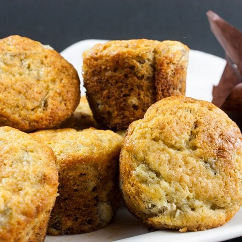 Best Ever Banana Muffins stacked on a white plate.