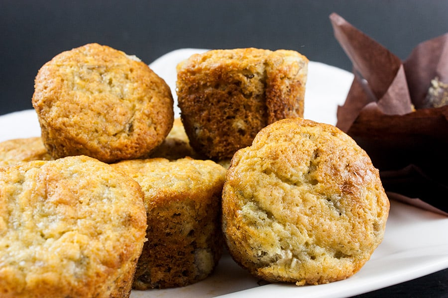 Best Ever Banana Muffins stacked on a white plate.