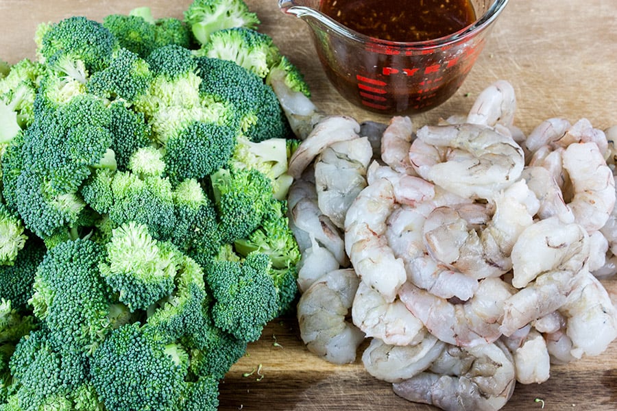 Shrimp and Broccoli Stir Fry  -  raw shrimp, chopped broccoli, and sauce mixture on a cutting board