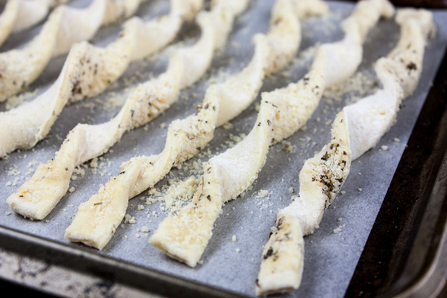 Pastry strips twisted on a parchment lined baking sheet.