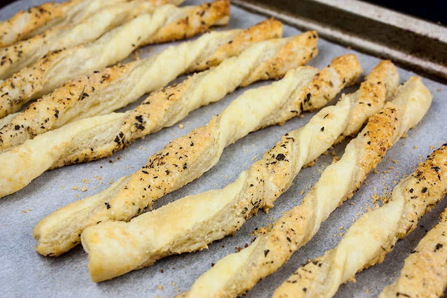 Baked cheese straws on baking sheet.