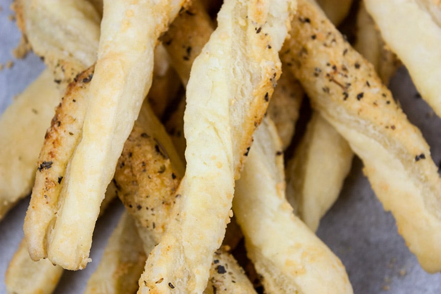 Close up of stacked cheese straws.