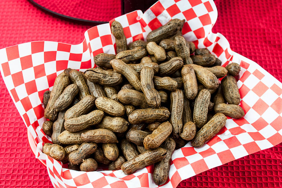 Boiled peanuts in a red and white paper lined basket.