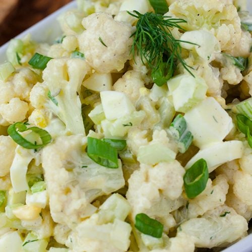 Cauliflower Mock Potato Salad in a white serving dish.