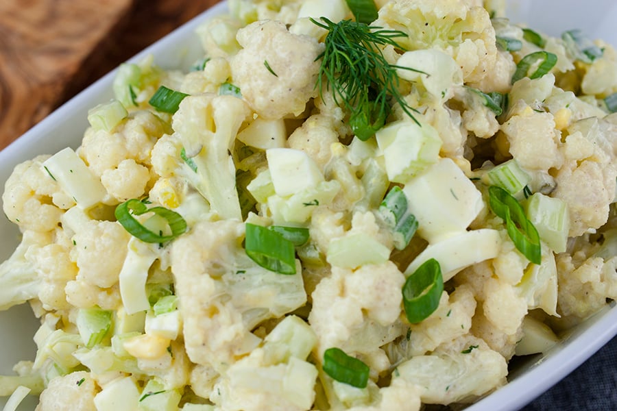 Cauliflower Mock Potato Salad in a white serving dish.