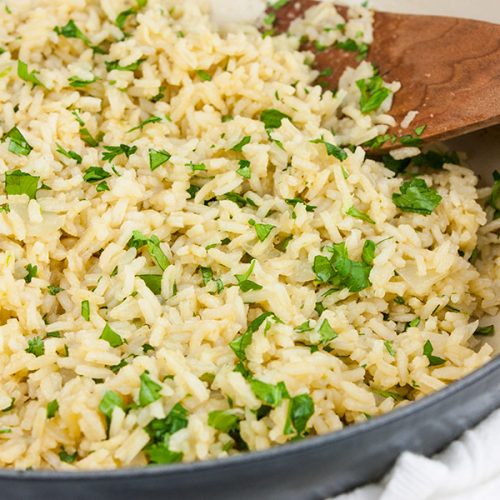 Cilantro lime rice in a gray skillet garnished with chopped cilantro.