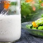 Southern buttermilk dressing in a mason jar with a salad in the background.