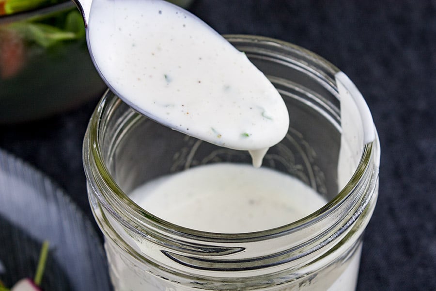 Southern Buttermilk Dressing - dressing coating a spoon over a mason jar
